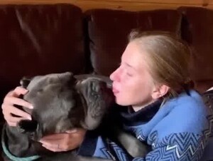 european woman sensually kissing her dog